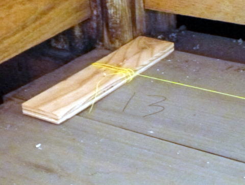 合板の切れ端に水糸を巻いて床に固定した
