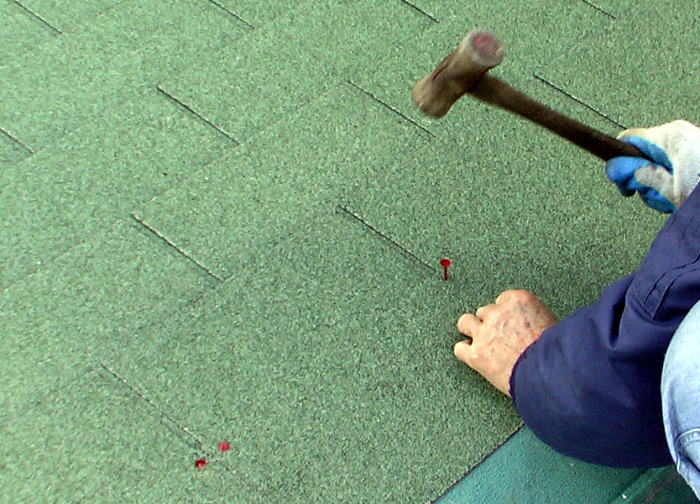 屋根材のアスファルトシングルを貼り付ける作業